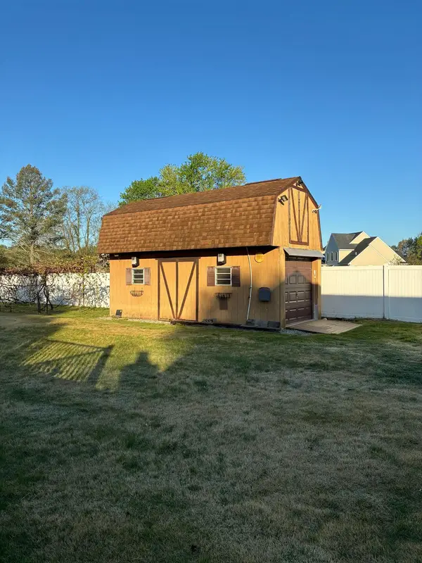 Barn-style shed with a brown gambrel shingle roof