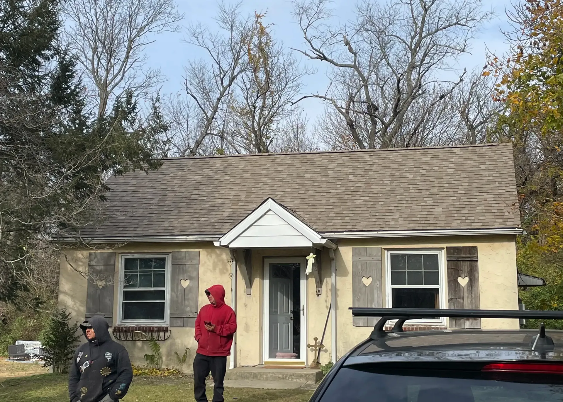 BE Roofing crew standing in front of a Cape Cod home with a newly installed roof