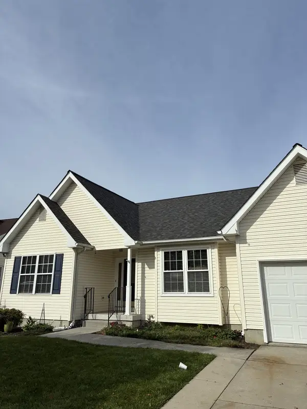Cream ranch home with an attached garage and a new dark gray shingle roof