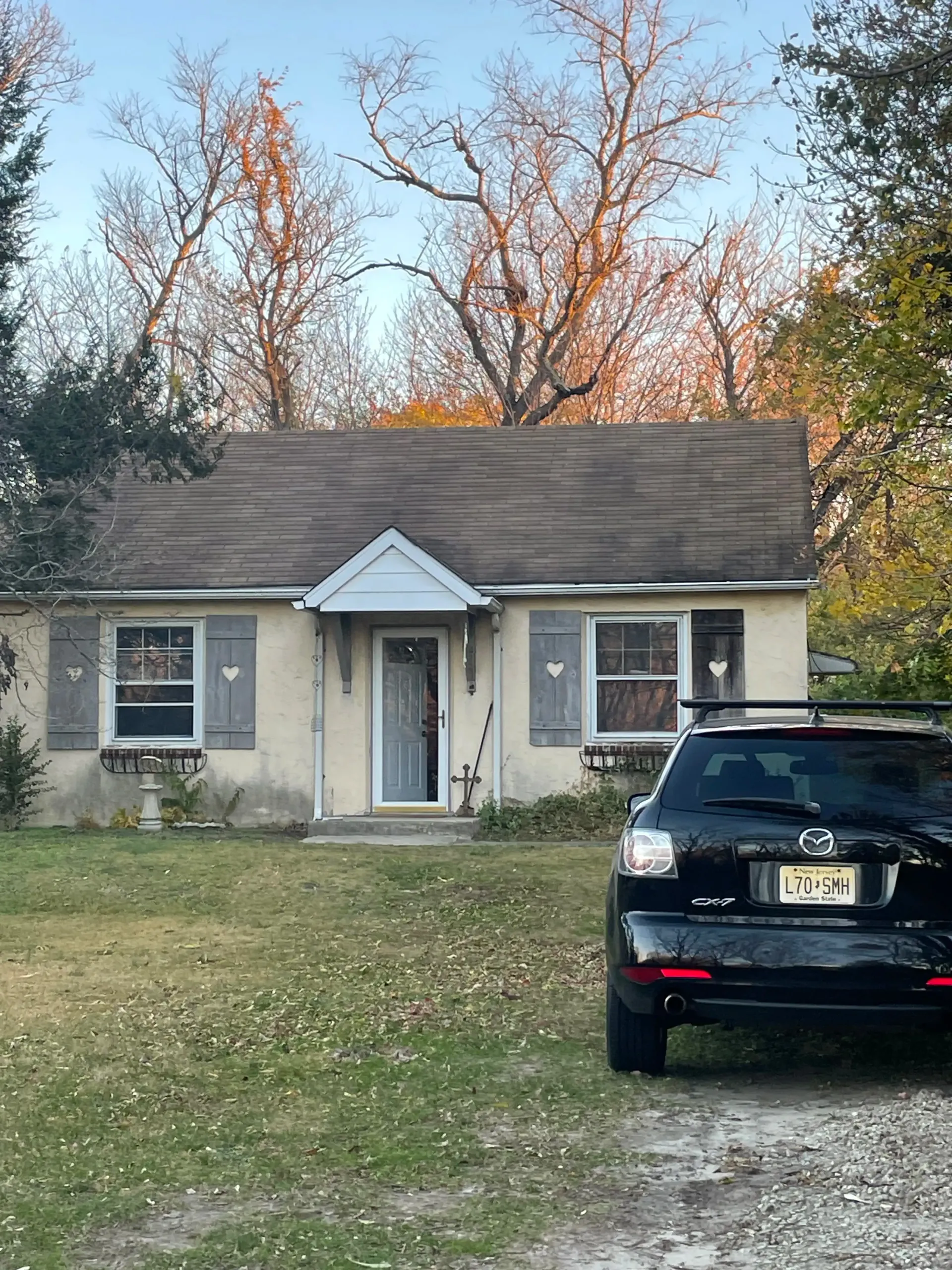 Cape Cod home with worn roof before